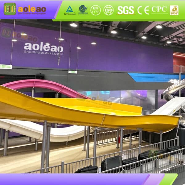 Yellow and pink wave slides for commercial indoor slide parks